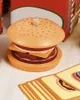 A wooden toy burger is displayed on a white surface, with a stack of cards in the foreground. Náhľad obrázku produktu