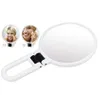 A white folding hand mirror with two smaller inset images showing a woman using the mirror. Produktbild-Vorschau