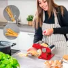 A woman is using a red pasta maker in a kitchen. Produktbild-Vorschau