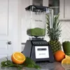 A Blendtec blender is shown on a kitchen counter with fresh ingredients like oranges and pineapple, along with a finished smoothie. Voir les images du produit