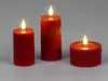 Three red LED candles of varying heights and one wider, shorter candle are arranged on a plain gray surface. Produktbild-Vorschau