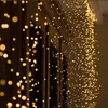 A close-up view of warm white LED fairy lights draped over a dark, textured surface, possibly a building facade or window frame. Produktbild-Vorschau
