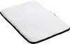 A white fluffy mat with a black border on a white background. Produktbild-Vorschau