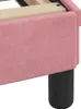 A close-up view of the corner of a pink upholstered bed frame with a black leg. Voir les images du produit