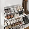 A white shoe cabinet filled with various shoes on multiple shelves. Produktbild-Vorschau