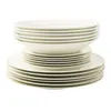 A stack of white porcelain plates and bowls with a thin gold rim, isolated on a white background. Produktbild-Vorschau