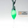 A single green LED light bulb from a string of lights is shown with water droplets falling on it, indicating it is waterproof. Produktbild-Vorschau