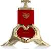 A red perfume bottle with gold accents and a heart-shaped gold hand stand. Voir les images du produit