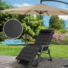 A black reclining lounge chair with a cushion and headrest is set up on a wooden deck in a garden setting, with a large tan umbrella overhead. Voir les images du produit