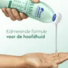 A hand is pouring shampoo from a bottle into another hand. Produktbild-Vorschau