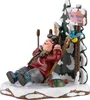 A wooden figurine of a skier resting in the snow next to a tree and a signpost. Produktbild-Vorschau