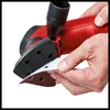A close-up shot of a person's hands attaching a triangular sanding sheet to a red delta sander. Náhľad obrázku produktu