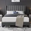 A bedroom scene featuring a dark gray upholstered bed with white bedding and a beige throw blanket. Podgląd zdjęcia produktu