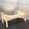A wooden toilet stool is placed in front of a toilet in a bathroom. Náhled obrázku produktu