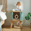 A bedside table next to a bed, with a lamp, books, and a vase on it. Podgląd zdjęcia produktu