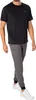 A man wearing a black t-shirt and gray joggers, posing for a product shot. Produktbild-Vorschau