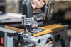 A person is using a cordless jigsaw to cut a pipe. Podgląd zdjęcia produktu