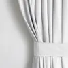 A close-up view of a white curtain with pleats and a fabric band. Produktbild-Vorschau