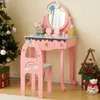A child's pink vanity table and chair set with a Christmas tree and gifts in the background. Podgląd zdjęcia produktu
