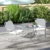 A patio set with two chairs and a small table is set up on a patio with greenery in the background. Náhled obrázku produktu