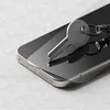 A close-up shot of a smartphone screen protector being applied to a smartphone, with a key resting on top. Anteprima dell’immagine prodotto