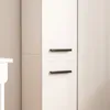 A close-up view of a modern white tall cabinet with black handles. Podgląd zdjęcia produktu