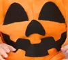 A close-up of a baby wearing a plush pumpkin costume. Anteprima dell’immagine prodotto