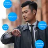 A man in a suit checks his watch while wearing a Bluetooth headset. Produktbild-Vorschau