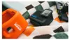 A GoPro camera and its accessories are laid out on a checkered towel. Anteprima dell’immagine prodotto