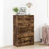 A wooden dresser with four drawers is shown in a room with a white wall and floor. A lamp and some framed pictures are on top of the dresser. Podgląd zdjęcia produktu