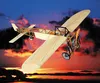 A model airplane is flying against a sunset sky. Voir les images du produit