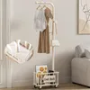 A coat rack with clothes and a bag hanging on it, and a storage basket at the bottom. Produktbild-Vorschau