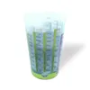 A clear plastic measuring cup with markings for different weights and types of food, filled with a light-colored granular substance. Produktbild-Vorschau