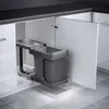 A pull-out trash bin system installed inside a kitchen cabinet. Produktbild-Vorschau