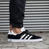 A person wearing black jeans and Adidas Gazelle sneakers. Produktbild-Vorschau