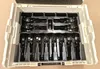 A white plastic case containing a set of black and silver tools, likely press jaws and rings. Voir les images du produit