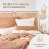 A neatly made bed with a woven headboard, featuring a close-up of the bedding and pillows, with decorative elements on the wall. Voir les images du produit