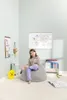 A young girl sits on a large gray beanbag chair in a child's room, with a world map poster on the wall and books on a shelf. Produktbild-Vorschau