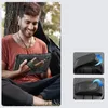 A man is sitting outdoors, holding a tablet in a protective case. Produktbild-Vorschau
