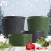 Christmas-themed marketing image featuring several planters in different sizes and colors, decorated with Christmas ornaments and pine branches. Voir les images du produit