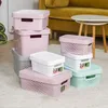 Several storage boxes of various sizes and colors are arranged on a rug in a living room setting, with a sofa and coffee table in the background. Náhľad obrázku produktu