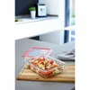A glass food container filled with salad on a wooden cutting board in a kitchen. Anteprima dell’immagine prodotto