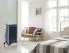 A dark gray electric radiator is shown in a bedroom setting next to a sofa and a bed. Anteprima dell’immagine prodotto