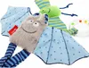 Two plush toys, a gray bat-like creature and a green striped creature, are shown against a white background. A clear ring with colorful beads is also visible. Produktbild-Vorschau