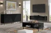 A modern living room setup featuring black furniture, including a sideboard, a coffee table, and a TV stand, with decorative items and a large window in the background. Produktbild-Vorschau