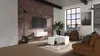 Loft-style living room with brick wall, modern furniture, and city view. Voir les images du produit