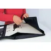A person is shown placing a binder into a black zippered organizer bag. Náhľad obrázku produktu