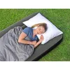 A woman sleeping on an inflatable mattress outdoors on grass. Náhled obrázku produktu
