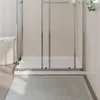 A close-up view of a shower tray with a shower curtain and a basket of towels. Produktbild-Vorschau
