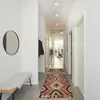 A modern hallway with a bench, mirror, rug, and doors. Produktbild-Vorschau